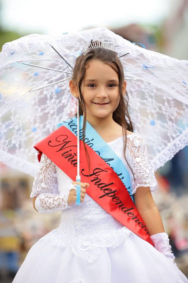 Esta hermosa niña luce un vestido blanco que lo engalana con su gran sonrisa.