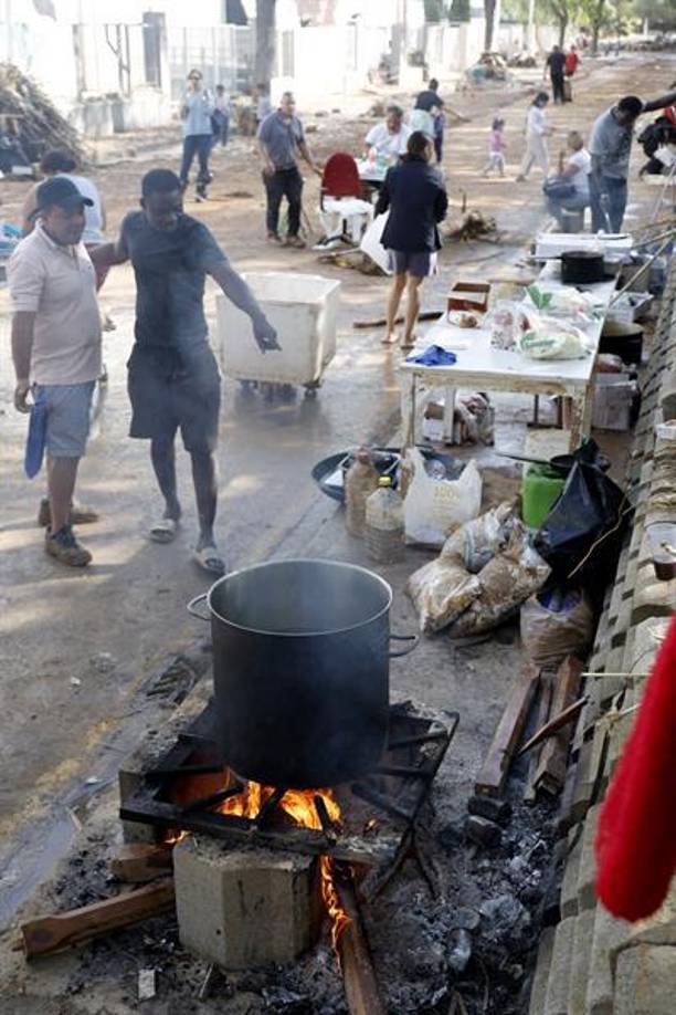 Vecinos se reúnen en las calles para compartir alimentos tras la devastación causada por las inundaciones.