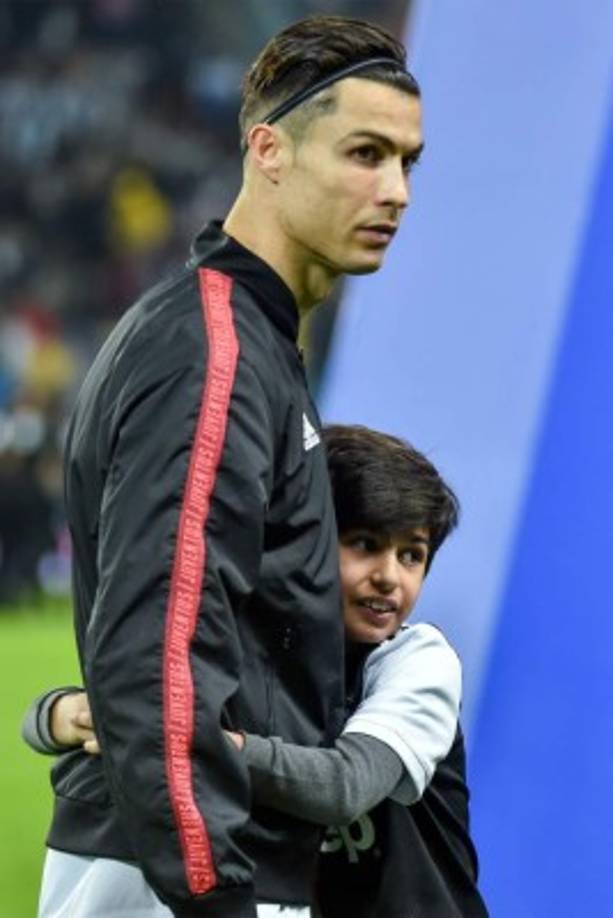 Un niño abraza a Cristiano Ronaldo antes del inicio del partido de la Supercopa italiana.
