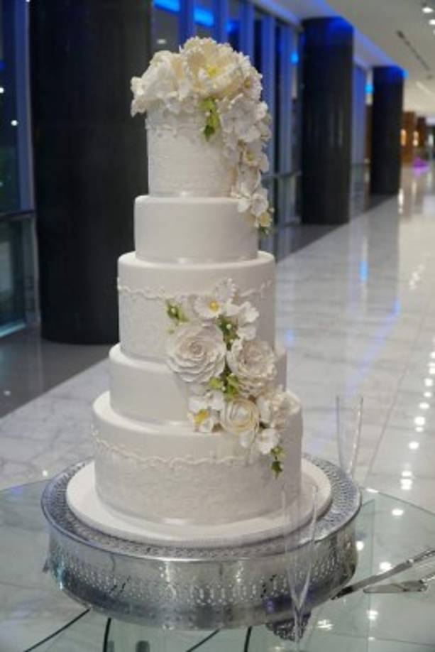 El pastel fue una torta tradicional con dos hermosos y delicados buqué de peonías, orquídeas y rosas en pastillaje, firmado por Adballah Canahuati de Signatures Cake.