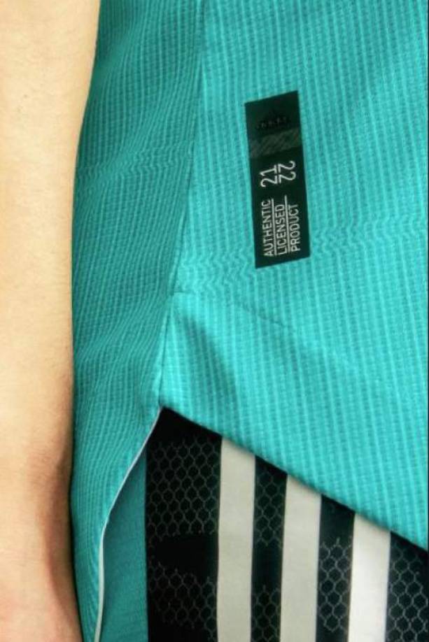 Detalles de la equipación. En el interior hay una brújula que simboliza la placa del Kilómetro Cero de Madrid, diseñada en un sutil gráfico que aparece tanto en la parte trasera como delantera de la camiseta. 