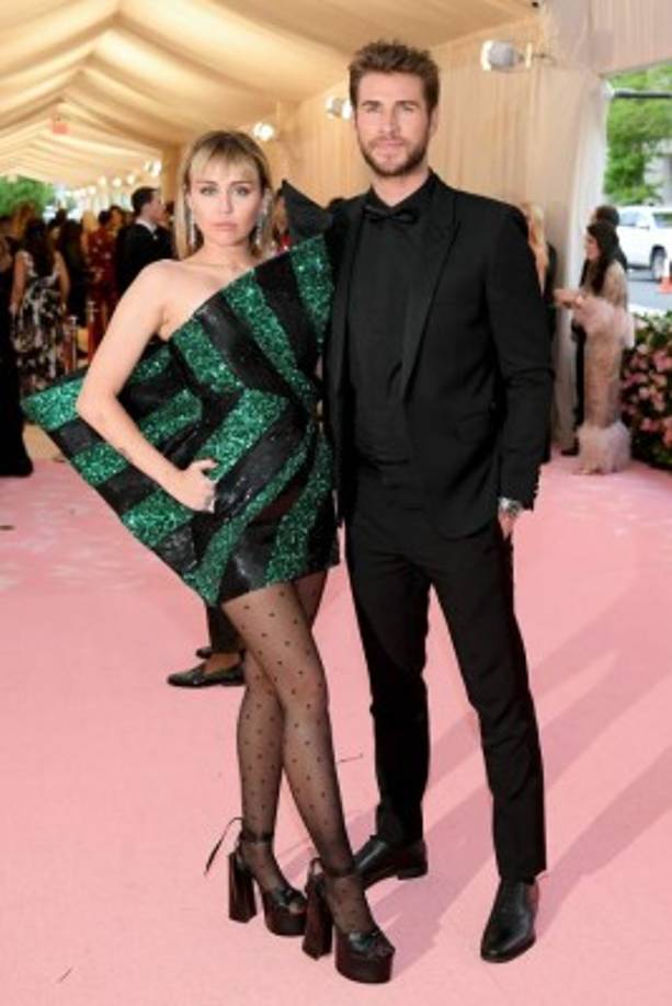 Miley Cyrus no defraudó con un diseño de lentejuelas de corte asimétrico de Saint Laurent que combinó con unas extravagantes sandalias de la misma marca. La cantante posó junto a su esposo, el actor Liam Hemsworth.
