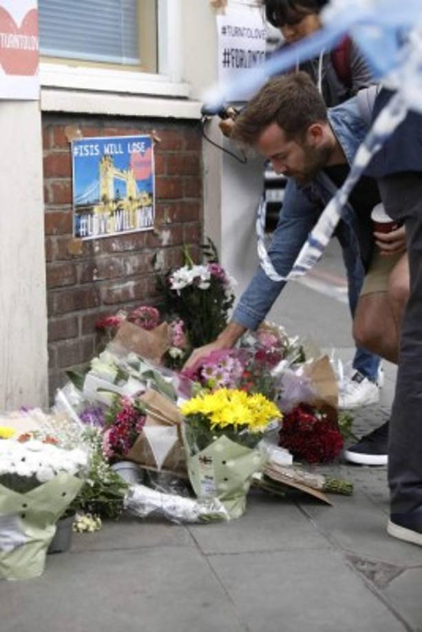 Un hombre deposita un ramo de flores en un memorial improvisado en el lugar del atentado.