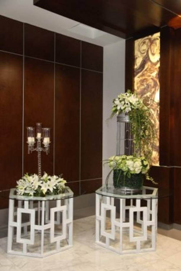 Mesas caladas con arreglos de lirios y hortensias.