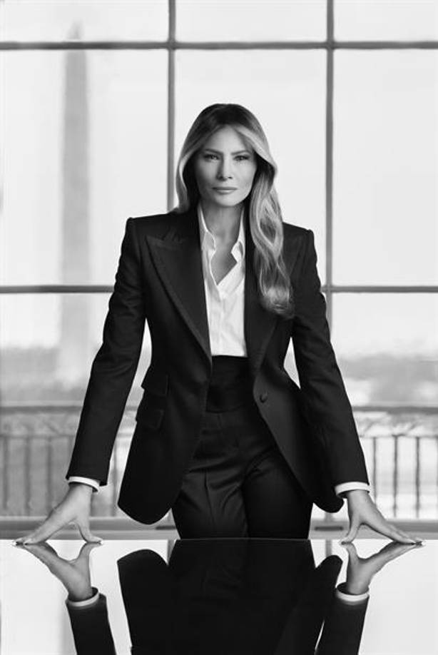 El retrato muestra a Melania de pie detrás de una mesa sobre la que está apoyada con las manos y frente a un ventanal con el característico obelisco del Monumento a Washington de fondo. La primera dama está con un posado serio y viste un traje oscuro de chaqueta y pantalón y una camisa blanca.