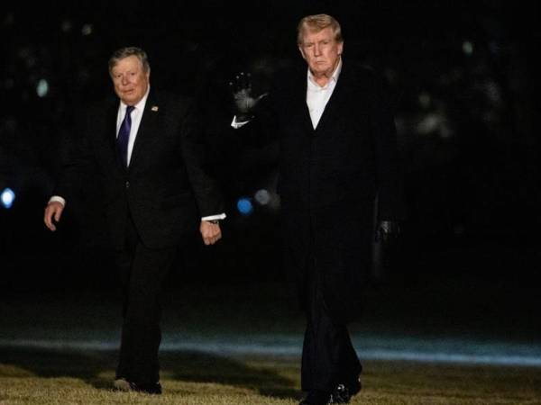 Trump saluda mientras camina con su suegro, Viktor Knavs, a su regreso a la Casa Blanca en Washington DC.