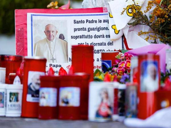 Los fieles dejan velas y tarjetas para el Papa Francisco en la entrada del Hospital Gemelli.