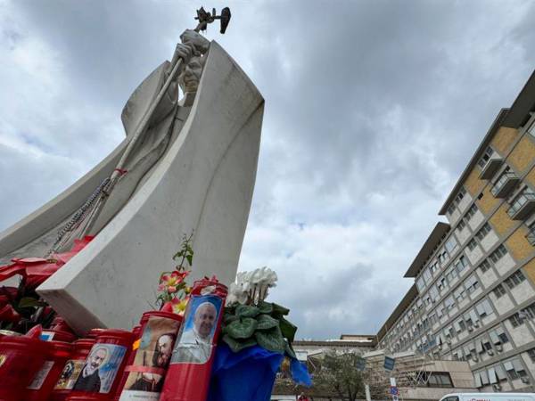 Velas y flores a las puertas del Hospital Gemelli de Roma donde permanece ingresado el papa Francisco.