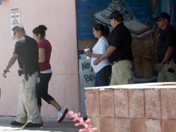 Agentes del Servicio de Inmigración y Aduanas (ICE) detienen a dos mujeres indocumentadas.