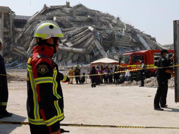 Equipos de rescate buscan a personas atrapadas entre los escombros de edificios destruidos tras el terremoto.