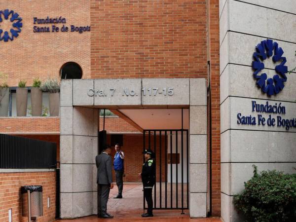Una integrante de la policía custodia una entrada de la Fundación Clínica Santa Fe donde es atendido el senador y precandidato presidencial Miguel Uribe Turbay en Bogotá.