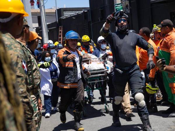 Un hombre es trasladado luego de ser rescatado de entre los escombros en la discoteca Jet Set este martes, en Santo Domingo.
