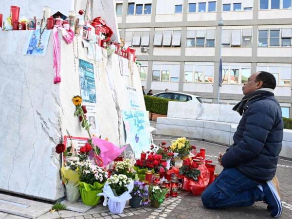 Un hombre reza por la salud del Papa frente a un improvisado altar a las afueras del hospital Gemelli de Roma.