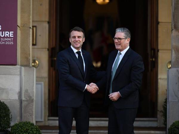 El primer ministro británico, Keir Starmer (d), saluda al presidente francés Emmanuel Macron a su llegada a la cumbre sobre Ucrania en Londres.