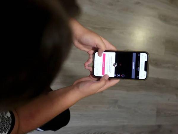 Una adolescente revisa su teléfono móvil en una imagen de archivo.