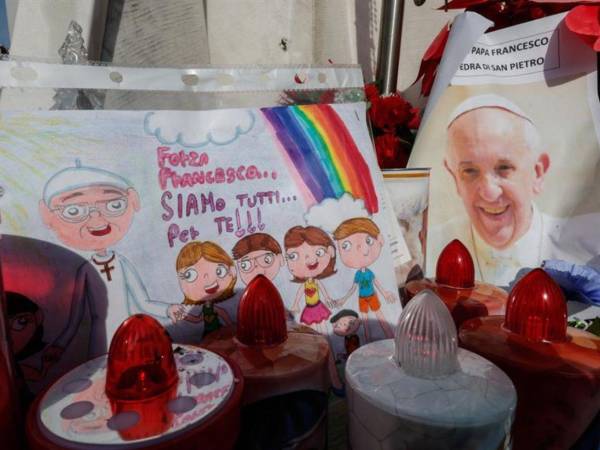 Un dibujo y una fotografía del papa Francisco bajo la estatua de Juan Pablo II, frente al Hospital Agostino Gemelli, donde se encuentra hospitalizado desde el 14 de febrero.