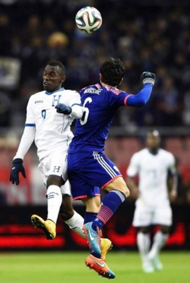 El jugador hondureño Alberth Elis salta por el balón contra el defensa japonés Masato Morishigein.