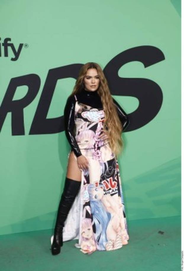 La intérprete lució un vestido largo con una abertura en la pierna, una blusa manga larga de color negro que combinó con unas botas altas.