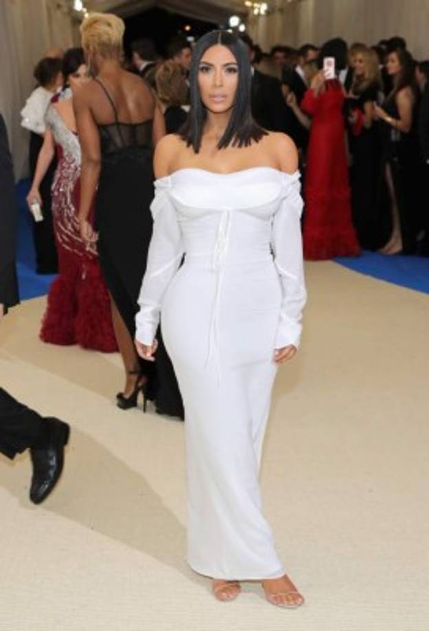 A diferencia de sus hermanas, Kim Kardashian llegó bien recatada en un vestido blanco.