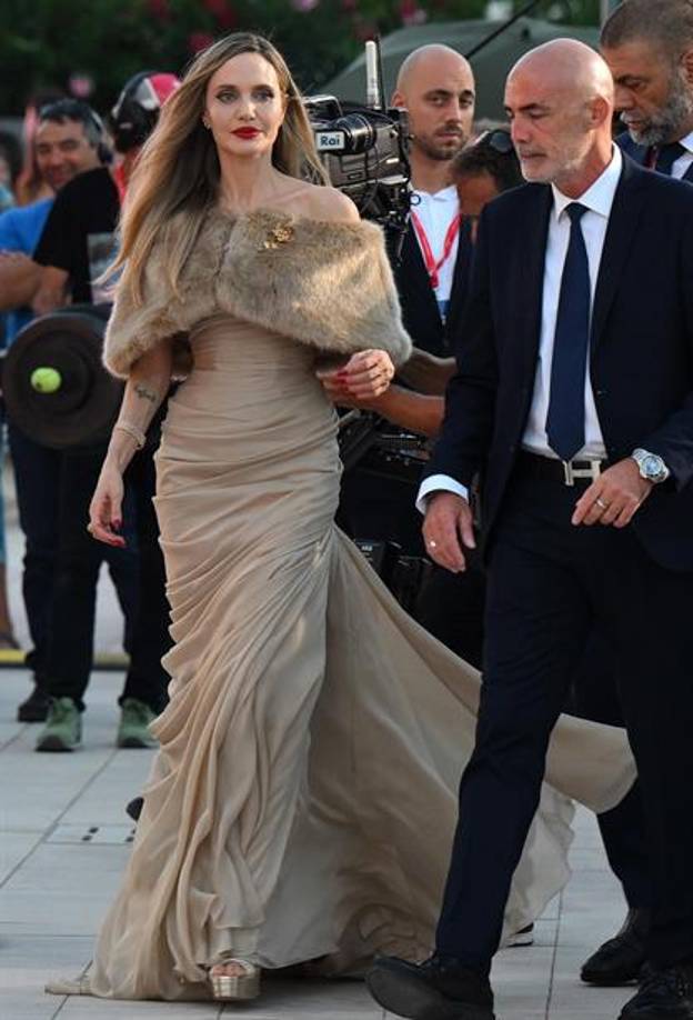 Angelina Jolie deslumbró este jueves en la alfombra roja de Venecia a su llegada al estreno de ‘María’, la película sobre la cantante de ópera María Callas dirigida por Pablo Larraín que compite por el León de Oro de Venecia.Con un vestido largo color taupé rematado por una estola de piel que dejaba ver su tatuaje en la espalda y un broche dorado, Jolie fue recibida en el exterior del Palacio del Cine del Lido por una multitud eufórica que no daba crédito a estar viendo de cerca a la estrella de Hollywood.