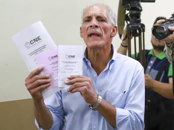 El candidato a la Presidencia de Honduras por el Partido Nacional, Nasry Asfura, muestra papeletas electorales antes de su de votación el domingo, en Tegucigalpa.
