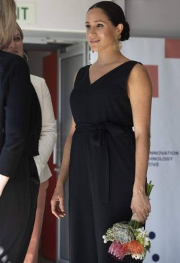 La duquesa de Sussex optó por un mono color negro y unos pendientes dorados para su cita en el Woodstock Exchange, un centro de arte y diseño en la Ciudad del Cabo.