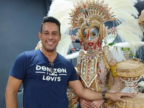 El diseñador panameño Alberto DCastro posa con Miss Grand Honduras, Yariela García, quien luce su creación La danza del colibrí esmeralda.