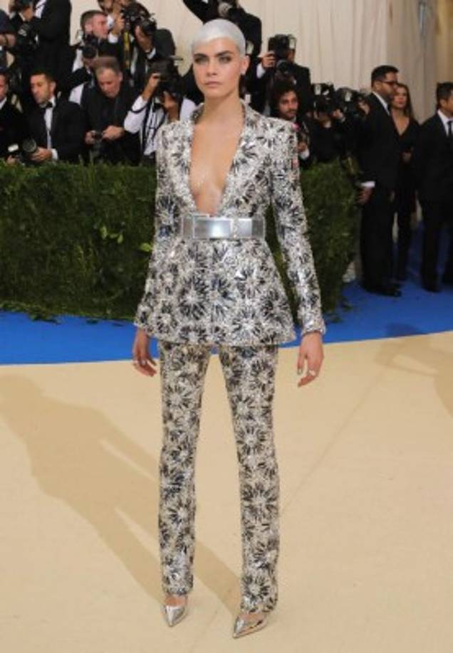 La modelo Cara Delevingne se ve algo rígida con sus pantalones y chaqueta decorados en pedrería.