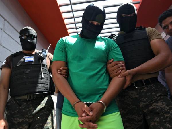 An inmate is escorted by Military Police officers to La Jaula, a maximum security unit at Tamara National Penitentiary, in Tamara, Francisco Morazan Department, just north of Tegucigalpa, on October 7, 2019. - La Jaula was converted into a maximum security unit to hold some of the most dangerous criminals in Honduras, including leaders of the Barrio 18 and MS-13 gangs and extortionists. (Photo by Orlando SIERRA / AFP)