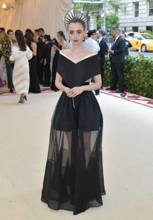 La actriz Lilly Collins es otra de las favoritas de la noche con un diseño de Givenchy, que se apega al código de vestuario reinventando el escapulario típico de las monjas en una versión sexy con una doble falda, con transparencia y rosario incluidos.