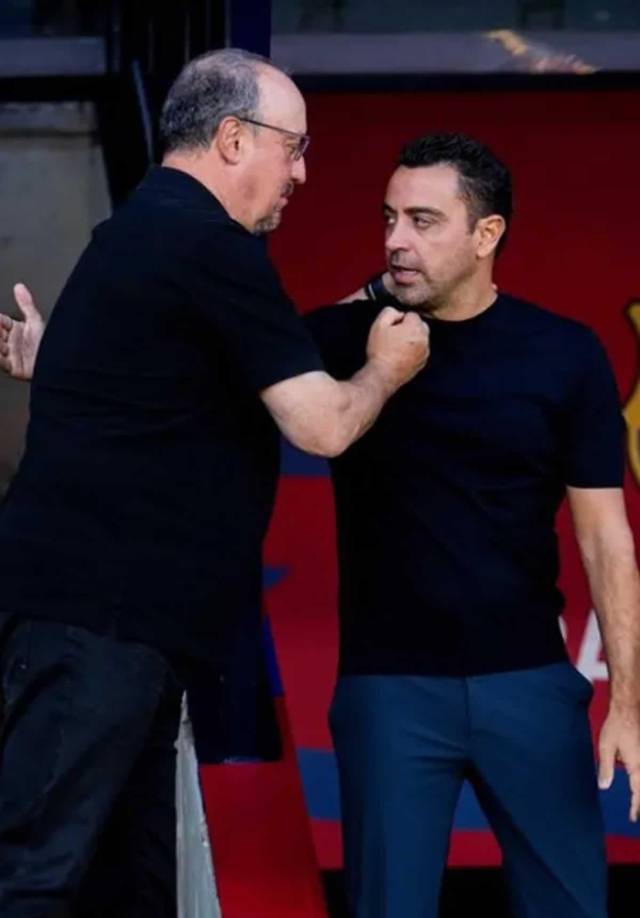 Xavi Hernández y Rafa Benítez se saludan antes del inicio del partido.