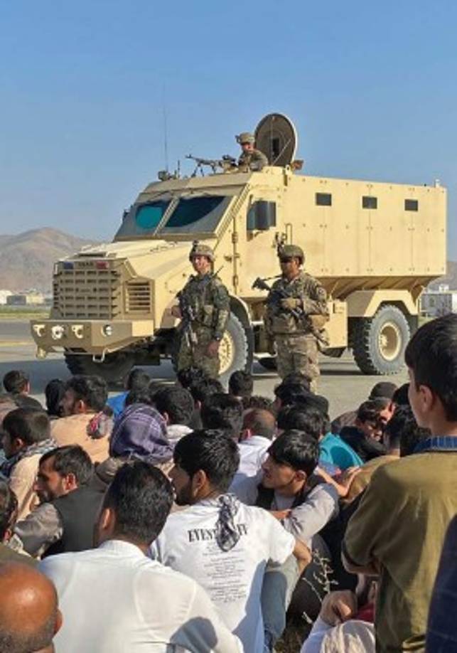 Afghans crowd at the airport as US soldiers stand guard in Kabul on August 16, 2021. (Photo by Shakib Rahmani / AFP)