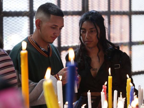 Una pareja de jóvenes encienden una vela para mostrar su fe a la Virgen de Suyapa en Tegucigalpa.