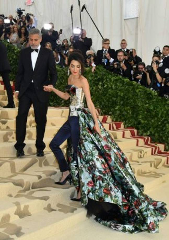 El corsé efecto metálico, diseñado por Richard Quinn, destacaba la figura de la prominente abogada. Su atuendo fue alabado por los críticos en moda, mientras que en redes sociales fue víctima de memes.<br/><br/>Amal es una de las anfitrionas de la Gala Met 2018, junto a Rihanna y Donatella Versace.