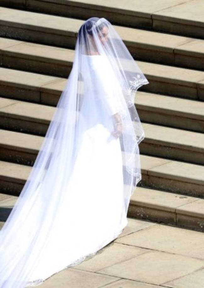 Meghan Markle lució un diseño muy sencillo, blanco inmaculado con escote de cuello de barco y cubrió su rostro con un velo transparente, adornado con bordados en los bordes hechos de organza y con una cola de cinco metros de longitud.<br/><br/>El diseño fue la británica Clare Waight Keller.