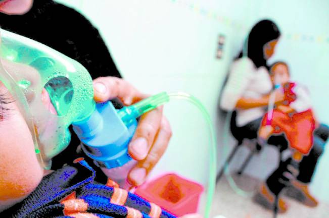 <b>Dos niños son atendidos por complicaciones respiratorias en un hospital de Honduras. Fotos: La Prensa</b>