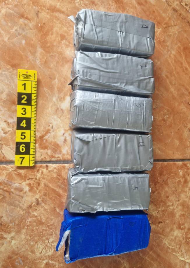 Dos armas de fuego, una marca Taurus, negra y otra Desert Eagle cromada.