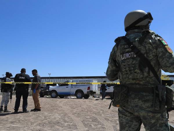 Integrantes de la policía y del ejercito custodian la zona donde fue hallado el cuerpo sin vida de un migrante este viernes, en ciudad Juárez, estado de Chihuahua (México).