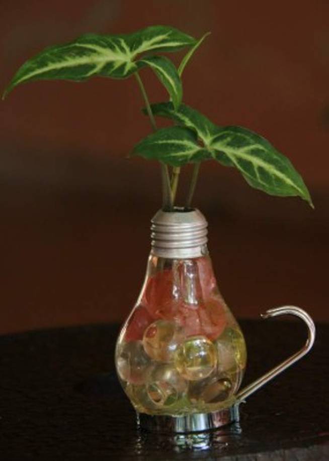 Maceta hecha con un bombillo de luz. Pegue el foco en una base de metal y luego inserte una planta pequeña.