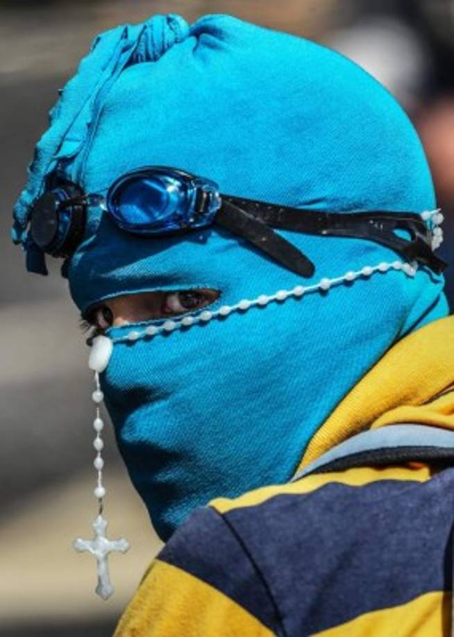 TOPSHOT - An opposition demonstrator during a protest in Caracas, on June 26, 2017<br/>A political and economic crisis in the oil-producing country has spawned often violent demonstrations by protesters demanding Maduro's resignation and new elections. The unrest has left 75 people dead since April 1. / AFP PHOTO / JUAN BARRETO