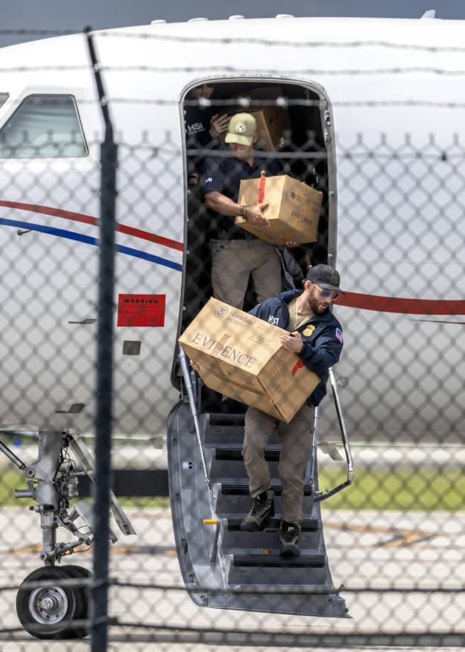 Oficiales extraen cajas etiquetadas como evidencia del avión que, según las autoridades, pertenece al presidente venezolano Nicolás Maduro en el Aeropuerto Ejecutivo de Fort Lauderdale, Florida. 