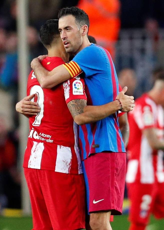 Luis Suárez se abraza con Sergio Busquets al final del partido.