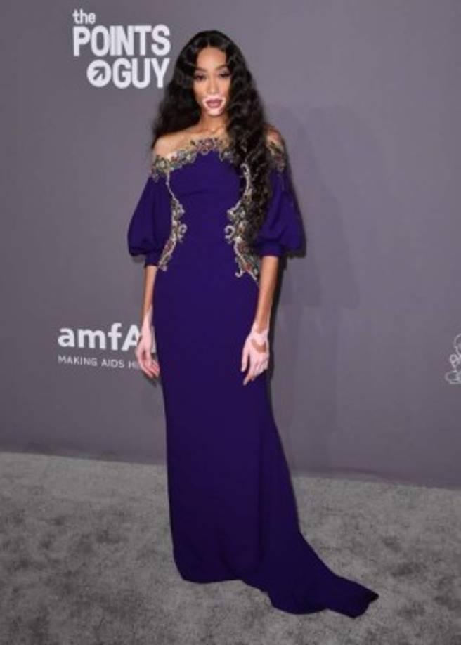 Winnie Harlow apostó por un vestido púrpura con detalles bordados y mangas voluminosas.<br/>