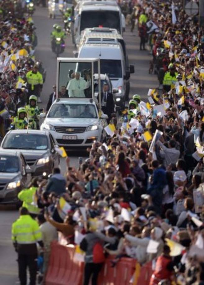 Pope Francis waves from the popemobile on his way to the Nunciature in Bogota on September 6, 2017.<br/>Pope Francis arrived in Colombia for a five-day tour to plead for a 'stable and lasting' peace in a divided country just emerging from a 50-year war that claimed hundreds of thousands of lives. / AFP PHOTO / Raul Arboleda