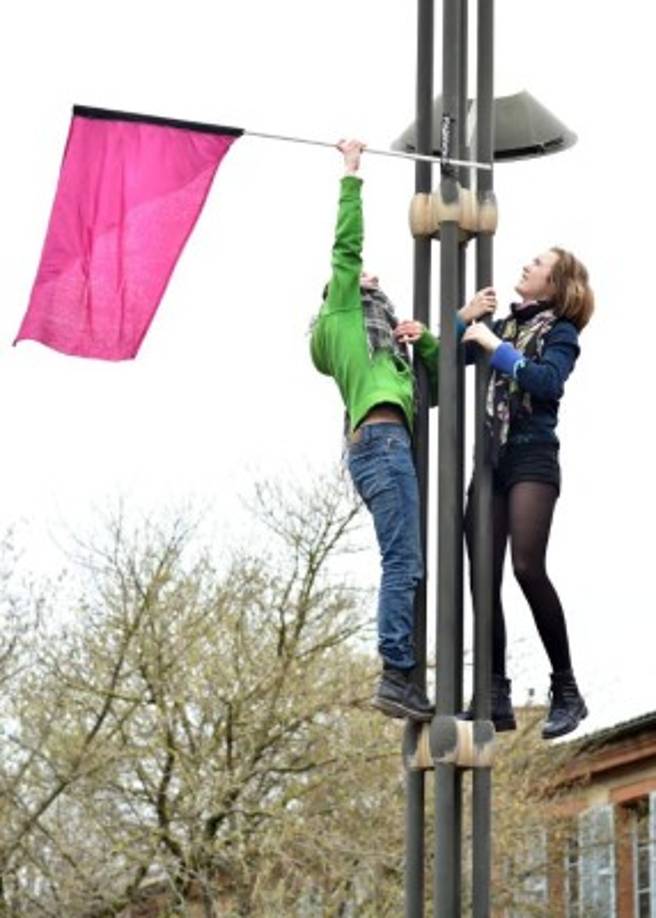 En Toulouse, Francia, dos mujeres comenzaron el día colgando una bandera color rosa como parte de las protestas por el Día Internacional de la mujer.