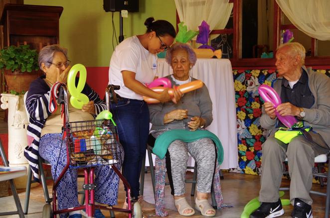 Fiahma Cruz, creadora de Atención Integral, atiende en un campamento lúdico a un grupo de adultos mayores.