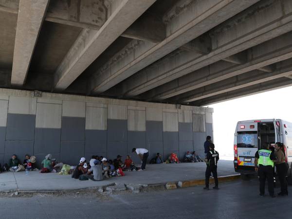 Migrantes permanecen debajo de un puente para cubrirse de los rayos solares debido a las altas temperaturas registradas en ciudad Juárez, en el estado de Chihuahua (México).