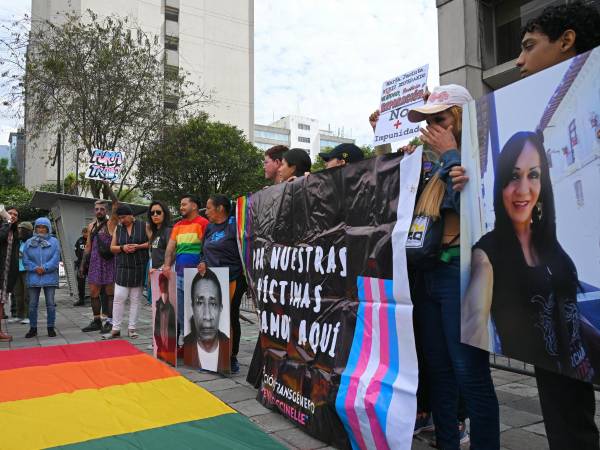 Personas sostienen carteles y fotografías de víctimas de violencia homofóbica frente al edificio de la Fiscalía del Estado para conmemorar el Día Internacional contra la Homofobia en Estados Unidos.