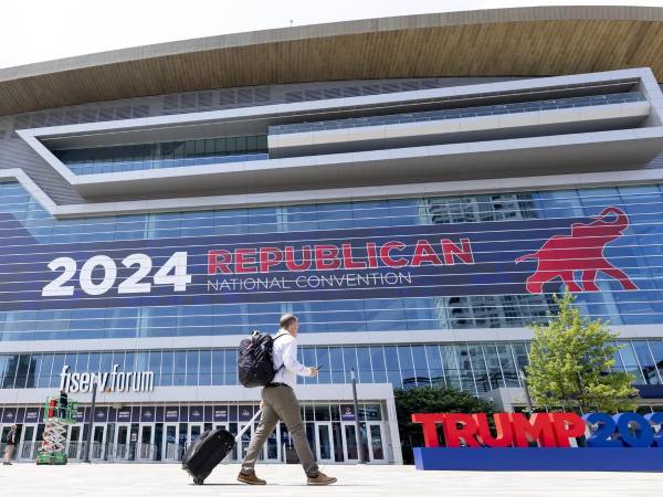Una persona pasa junto a un gran letrero de la Convención Nacional Republicana en el Foro Fiserv en Milwaukee, Wisconsin, EEUU.