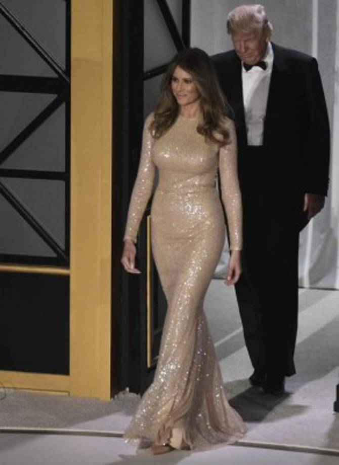 Para los tradicionales bailes de gala de la toma de posesión, Melania optó inicialmente por un diseño del creador libanés Reem Acra. La primera dama lució un vestido color 'nude', manga larga y tejido de paillettes.